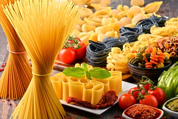 Композиція з різноманітністю макаронних виробів на кухонному столі — стокове фото