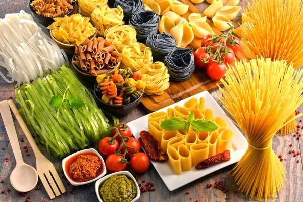 Композиція з різноманітністю макаронних виробів на кухонному столі — стокове фото