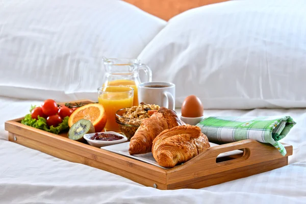 Frühstückstablett im Bett im Hotelzimmer — Stockfoto