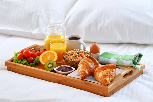 Frühstückstablett im Bett im Hotelzimmer — Stockfoto