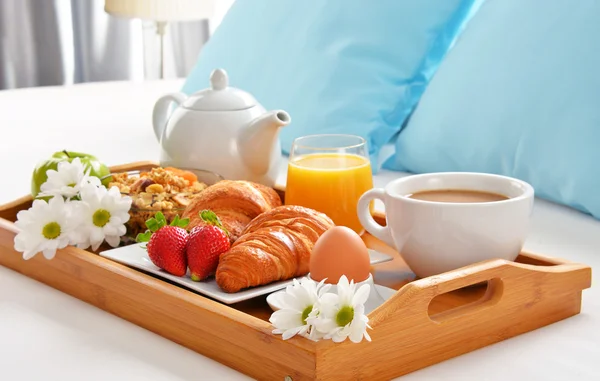 Bandeja de pequeno-almoço na cama no quarto do hotel — Fotografia de Stock