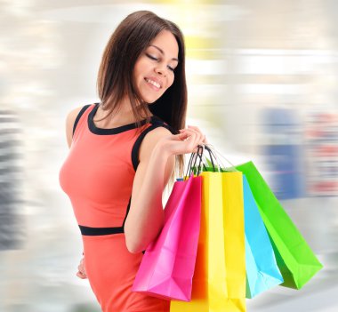 Alışveriş merkezinde çantalı genç bir kadın.