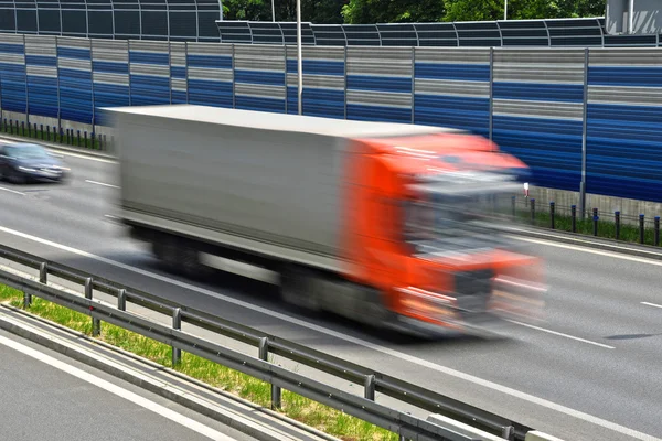 Veículo de mercadorias de grande porte que se desloca a toda a velocidade na estrada de seis faixas — Fotografia de Stock