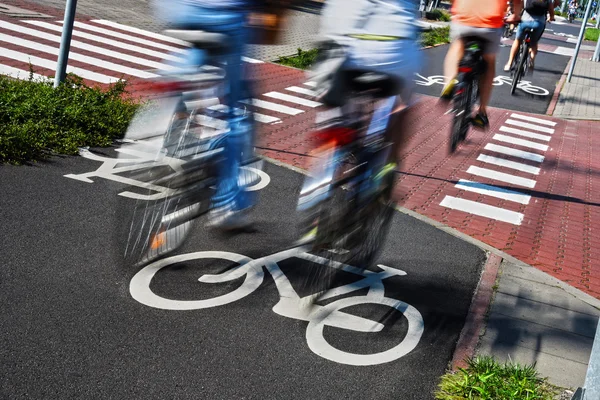 Bicycle road sign and bike riders — Stock Photo, Image