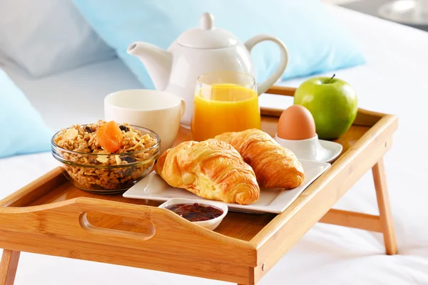 Śniadanie na tacy w łóżku w pokoju hotelowym — Zdjęcie stockowe