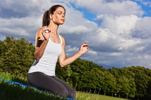 Jovem mulher durante meditação de ioga no parque — Fotografia de Stock