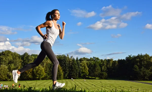 Mujer joven corriendo en el parque durante el entrenamiento deportivo — Foto de Stock