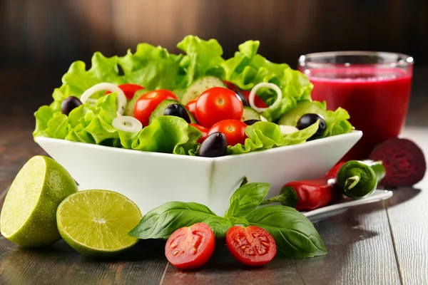 Состав с овощным салатом и стаканом сока — стоковое фото