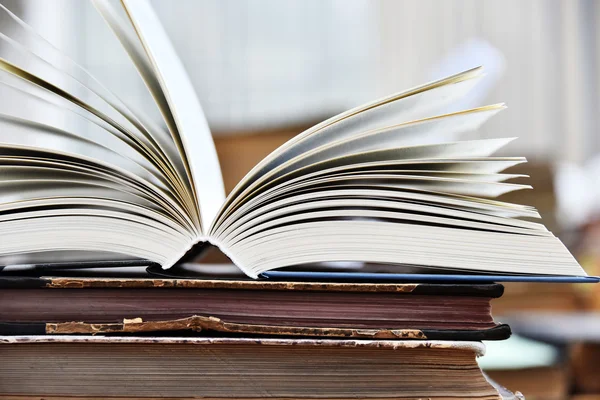 Libro de tapa dura acostado sobre la mesa en una biblioteca —  Fotos de Stock