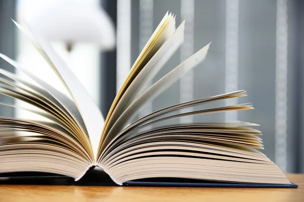 Libro de tapa dura acostado sobre la mesa en una biblioteca —  Fotos de Stock