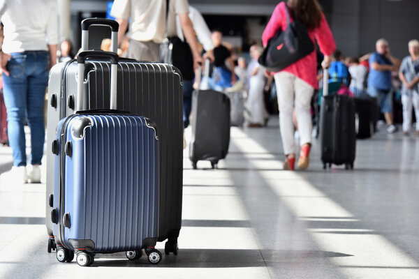 Two plastic travel suitcases in the airport hall