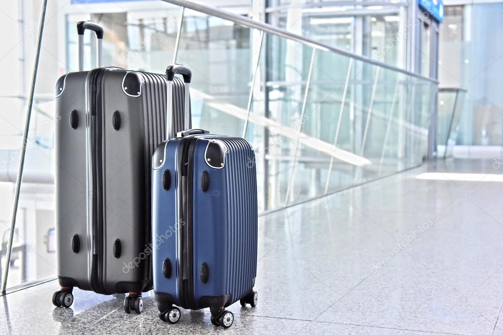 Two plastic travel suitcases in the airport hall