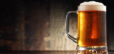 Ahşap arka planda bir bardak birayla kompozisyon.