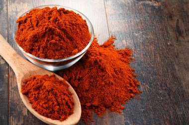 Ahşap masanın üzerinde bir kase biber tozu ile kompozisyon.