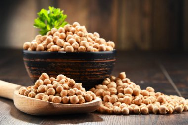 Ahşap masada bir kase nohut ile kompozisyon.