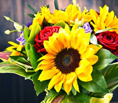 Ayçiçekleri ve güller de dahil olmak üzere bir buket çiçekle kompozisyon