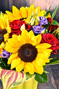 Ayçiçekleri ve güller de dahil olmak üzere bir buket çiçekle kompozisyon
