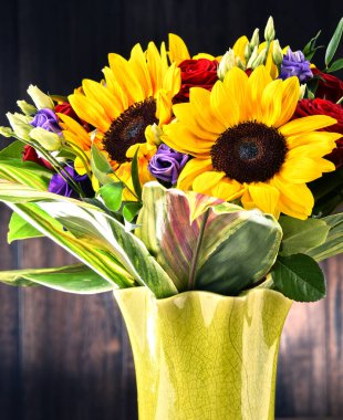 Ayçiçekleri ve güller de dahil olmak üzere bir buket çiçekle kompozisyon