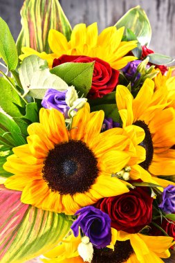 Ayçiçekleri ve güller de dahil olmak üzere bir buket çiçekle kompozisyon