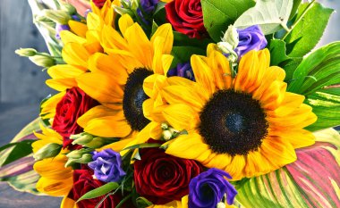 Ayçiçekleri ve güller de dahil olmak üzere bir buket çiçekle kompozisyon