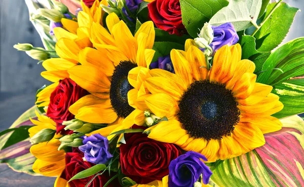 Ayçiçekleri ve güller de dahil olmak üzere bir buket çiçekle kompozisyon
