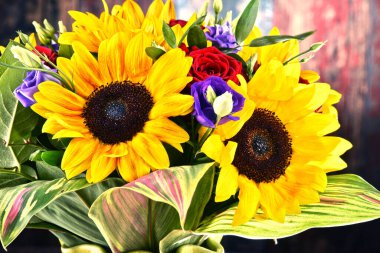 Ayçiçekleri ve güller de dahil olmak üzere bir buket çiçekle kompozisyon