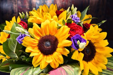 Ayçiçekleri ve güller de dahil olmak üzere bir buket çiçekle kompozisyon