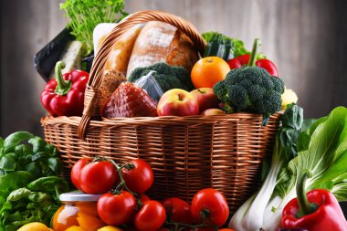 Taze sebze ve meyve içeren çeşitli sebze ürünleriyle dolu bir sepet.