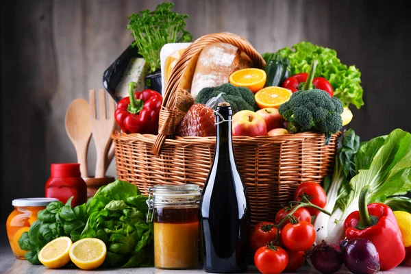 Wicker basket with assorted grocery products including fresh vegetables and fruits