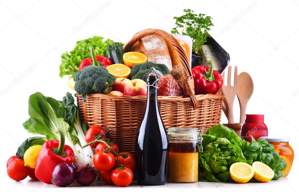 Wicker basket with assorted grocery products including fresh vegetables and fruits