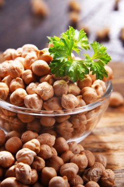 Ahşap masada bir kase nohut ile kompozisyon.