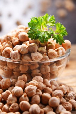 Ahşap masada bir kase nohut ile kompozisyon.