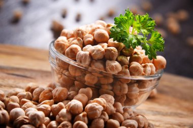 Ahşap masada bir kase nohut ile kompozisyon.