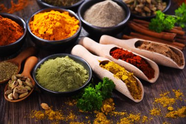 Ahşap mutfak masasında değişik baharatlar var..