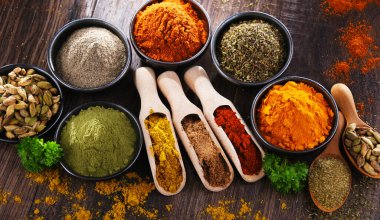 Ahşap mutfak masasında değişik baharatlar var..