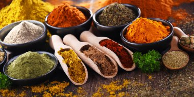 Ahşap mutfak masasında değişik baharatlar var..