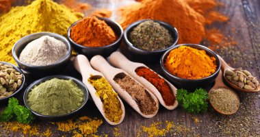 Ahşap mutfak masasında değişik baharatlar var..