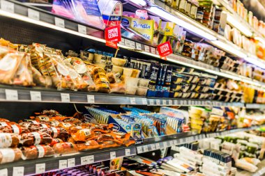 POZNAN, POL - 13 APR 2021: Ticari bir buzdolabında satışa sunulan gıda ürünleri