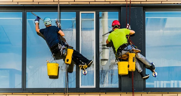 两名男子清扫一幢办公楼的窗户 — 图库照片
