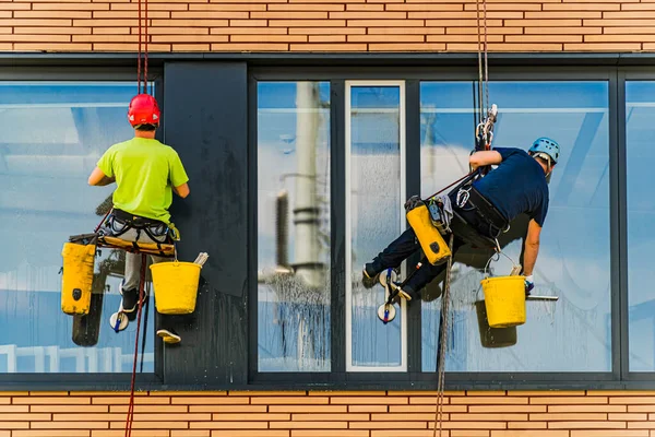 两名男子清扫一幢办公楼的窗户 — 图库照片