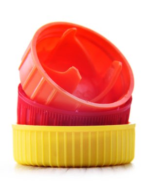 Beyaza izole edilmiş renkli plastik şişe kapakları. Geri dönüşüm