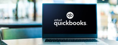 POZNAN, POL - SEP 23, 2020: Laptop computer displaying logo of QuickBooks, an accounting software package developed and marketed by Intuit clipart
