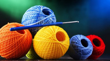 Değişik renkli ipliklerden oluşan kompozisyon ve örgü örmek için kanca.