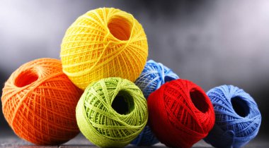Değişik renkli ipliklerden oluşan kompozisyon ve örgü örmek için kanca.