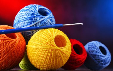 Değişik renkli ipliklerden oluşan kompozisyon ve örgü örmek için kanca.