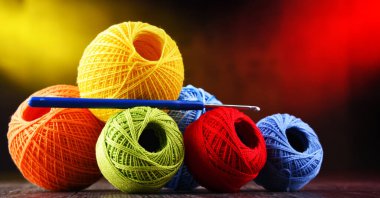 Değişik renkli ipliklerden oluşan kompozisyon ve örgü örmek için kanca.