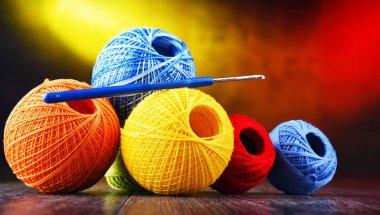 Değişik renkli ipliklerden oluşan kompozisyon ve örgü örmek için kanca.