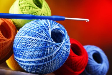 Değişik renkli ipliklerden oluşan kompozisyon ve örgü örmek için kanca.