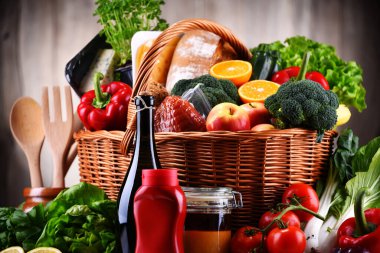 Taze sebze ve meyve içeren çeşitli sebze ürünleriyle dolu bir sepet.