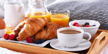 Otel odasındaki bir yatakta kahvaltı tepsisi..